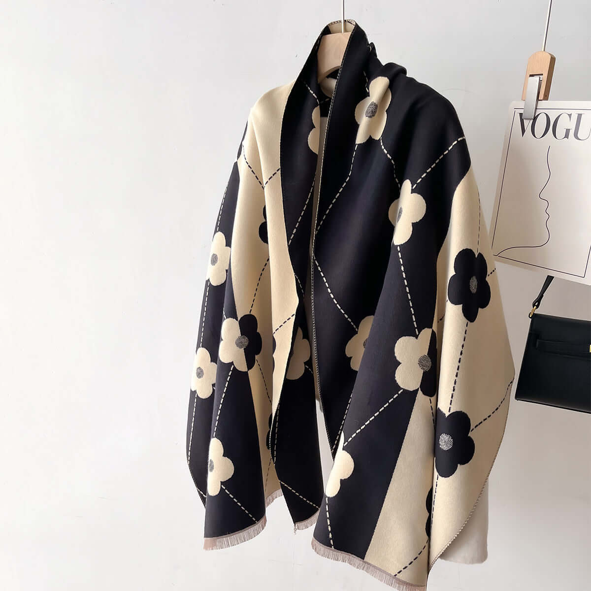 Black and beige patterned imitation cashmere scarf hanging elegantly, showcasing soft texture and chic floral design.