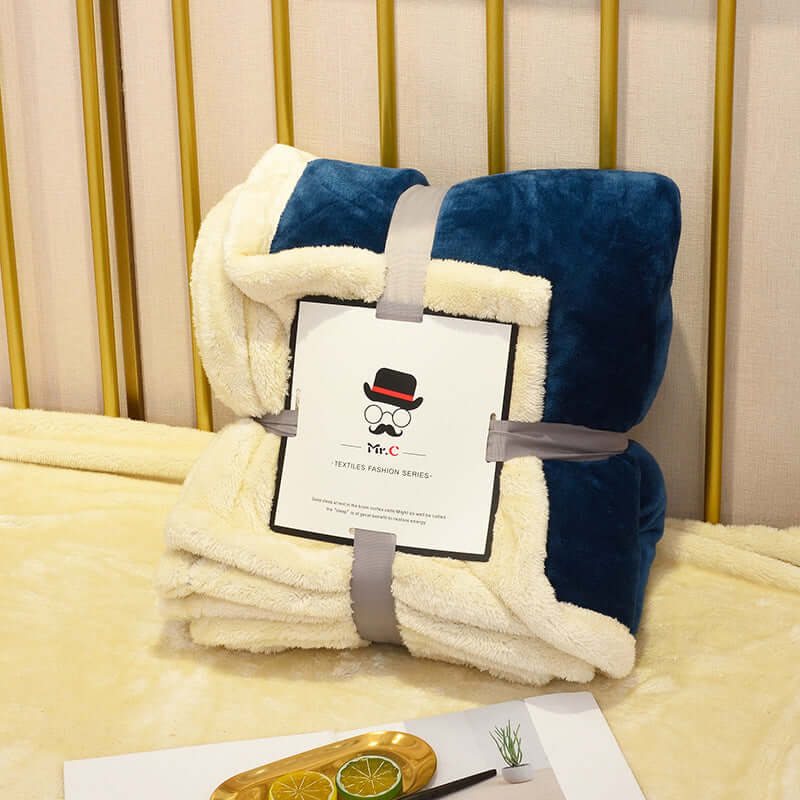 Flannel Plush Blanket folded and presented on a couch, showcasing its cozy, stylish design.