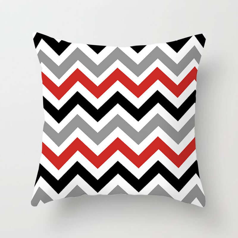 Decorative pillow for sofa featuring a modern zigzag pattern in red, black, gray, and white.