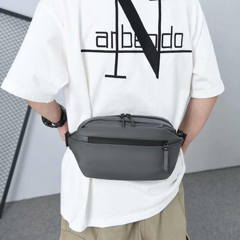 Person wearing a sleek High Capacity Waist Bag made of waterproof fabric, ideal for carrying essentials. Stylish and functional design.