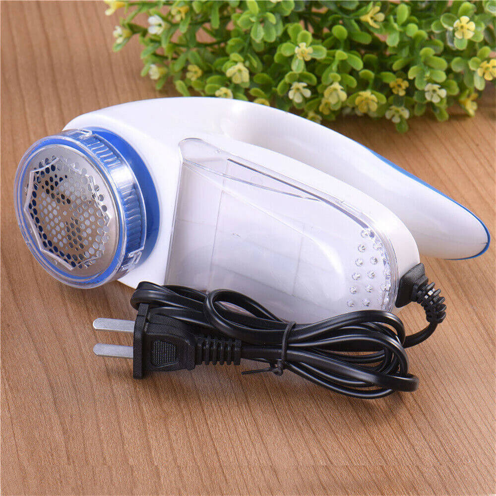 Lint Fabric Remover device with ergonomic handle and power cord on a wooden surface, ideal for removing fuzz and pet hair.