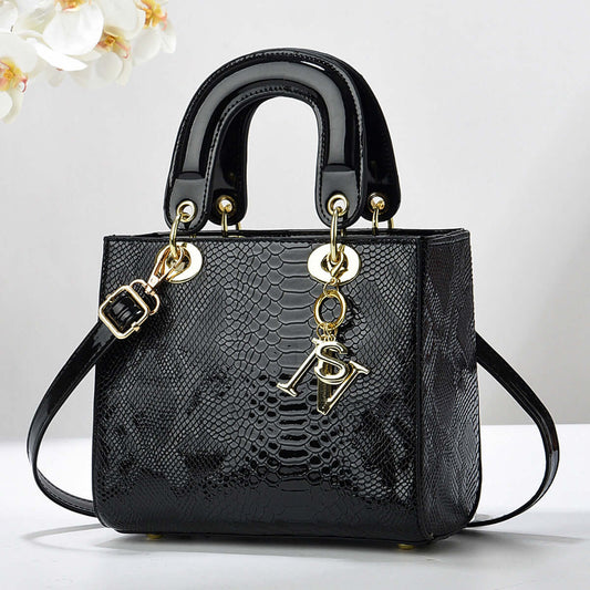 Elegant black textured handbag with gold accents and detachable strap, featuring a sleek design suitable for sophisticated outings.