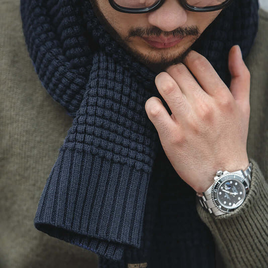 Man wearing navy wool knitted scarf and stylish watch, highlighting winter fashion accessory