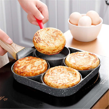 Four Hole Frying Pan in use, cooking pancakes with a hand lifting one out; eggs in background.