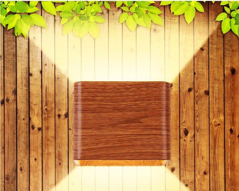 Indoor Wall Mounted Lamp illuminating wooden wall with natural leaves, enhancing the space's warmth and style.