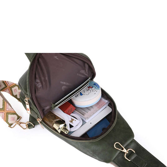 Ladies Cross Shoulder Bag open to show spacious interior with various items. Stylish, durable PU leather bag in elegant dark green.