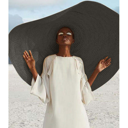 Stylish lady wearing a large straw sun hat and chic white dress, perfect for summer adventures and sun protection.