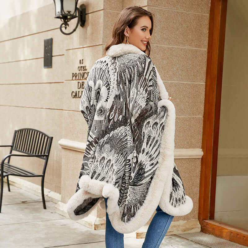 Elegant woman wearing a patterned shawl with faux fur trim, showcasing its stylish design and versatility.