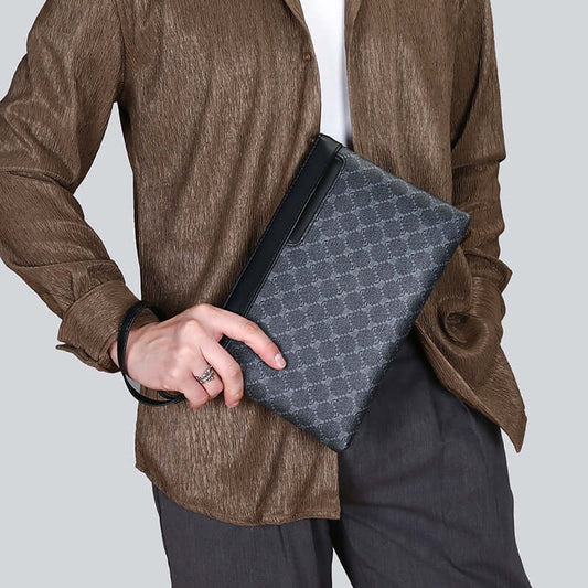 Person holding a stylish clutch hand bag with a geometric pattern, elegant and versatile for any occasion.
